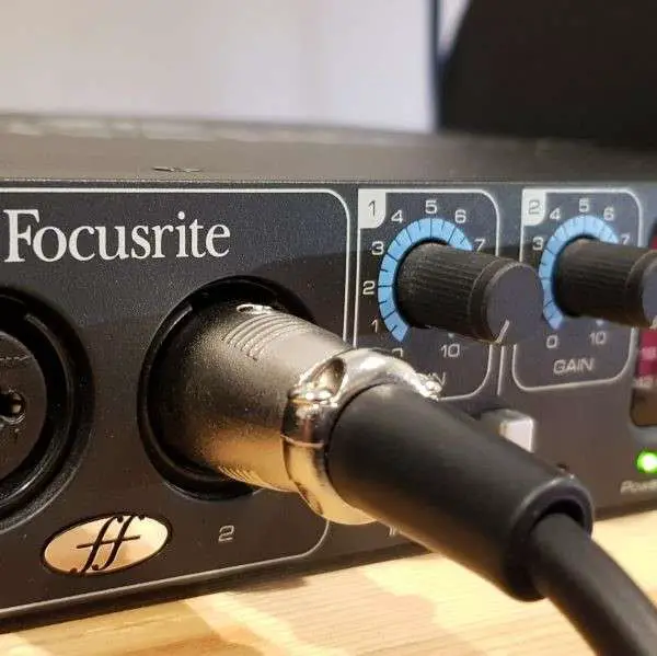 An XLR cable connected to an audio interface via its combo jack